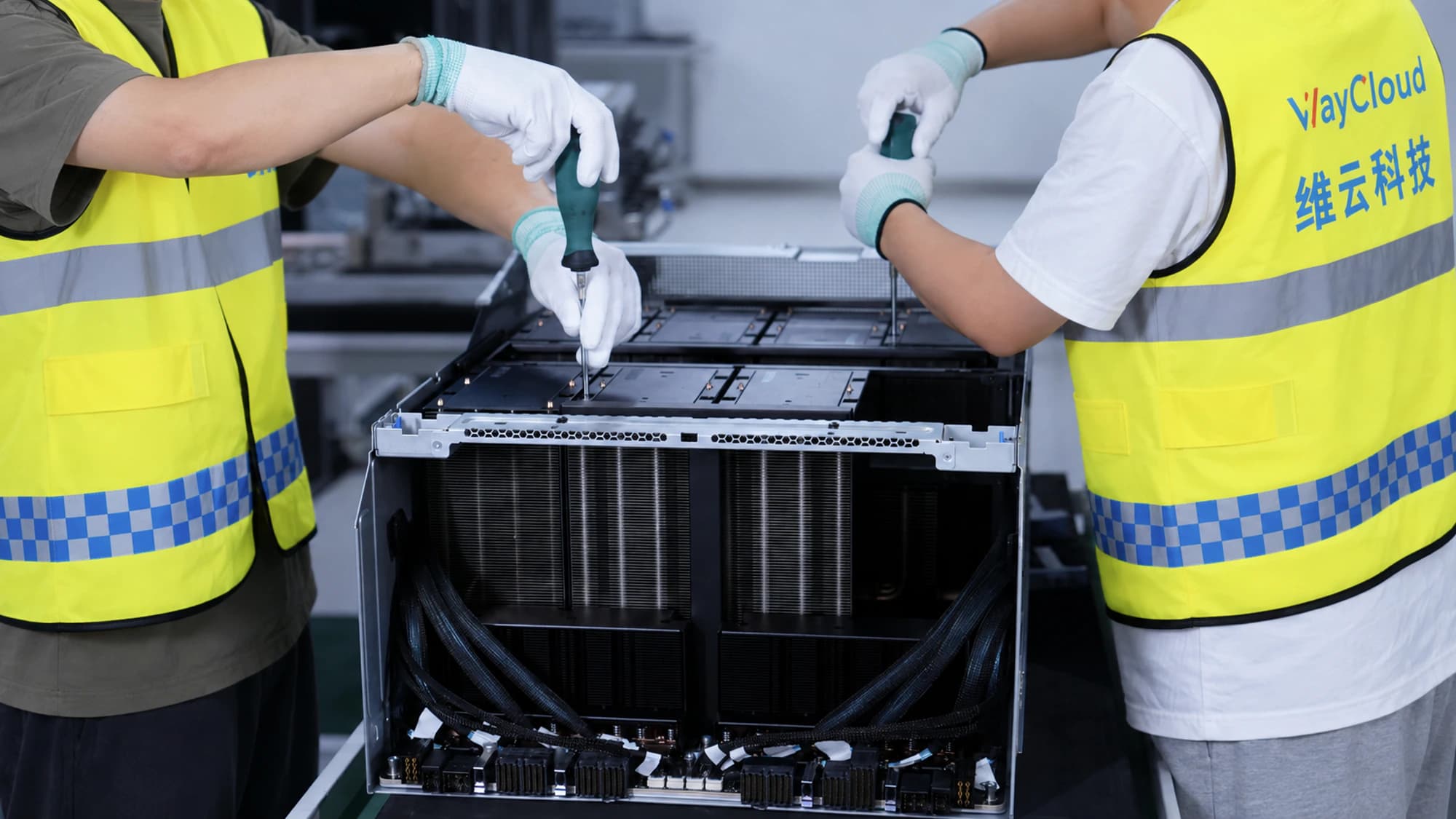 双人使用电动螺丝刀装配 GPU 托盘