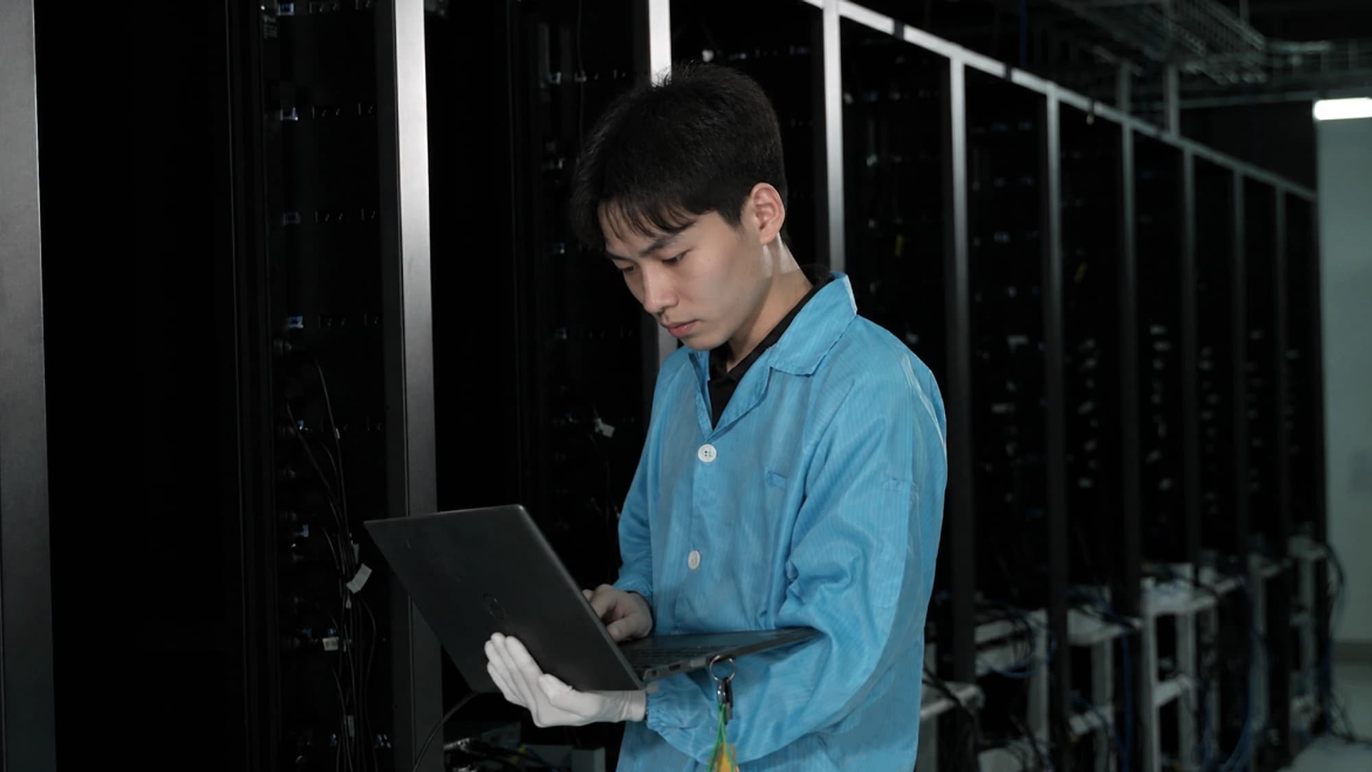 工程师持笔记本于机柜前诊断